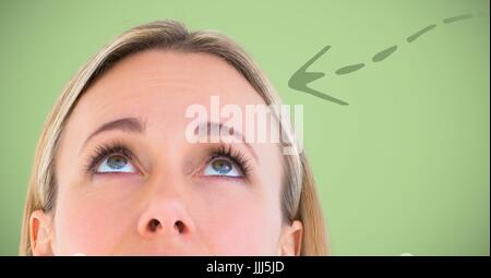 Top of woman's head and green downward arrow against green background Stock Photo