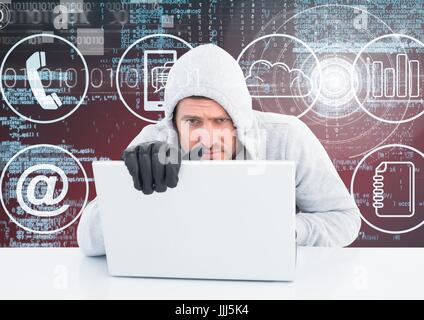 Hacker with gloves using a laptop in front of digital background Stock Photo