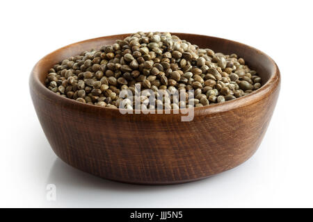 Hemp seeds in dark wooden bowl isolated on white. Stock Photo