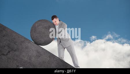 Man pushing rolling round rock Stock Photo