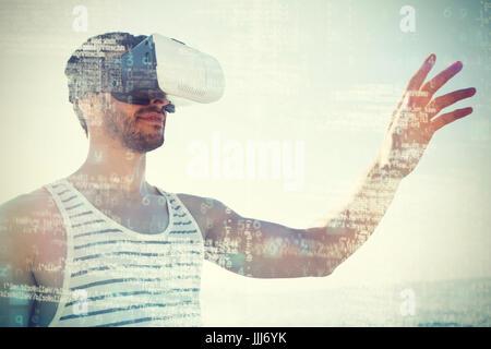 Young man using virtual reality 3d glasses at beach Stock Photo