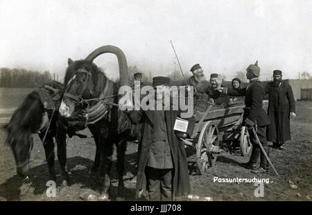 Checkpoint on Eastern Front in WWI by German soldier. Russian / Polish Jewish family travelling in horse and cart are stopped.  Caption reads:  Pass Untershuchung (Pass examination) Stock Photo