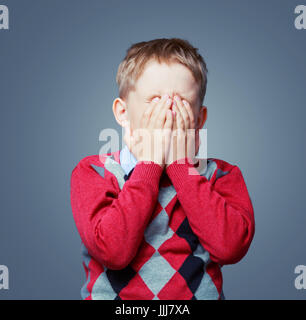 displeased crying boy isolated against grey background Stock Photo