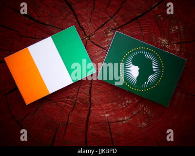 Ivory Coast flag with African Union flag on a tree stump isolated Stock Photo