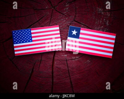 USA flag with Liberian flag on a tree stump isolated Stock Photo