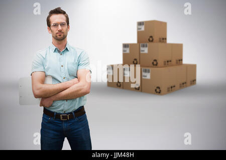 Composite 3d image of serious warehouse manager standing with arms crossed Stock Photo