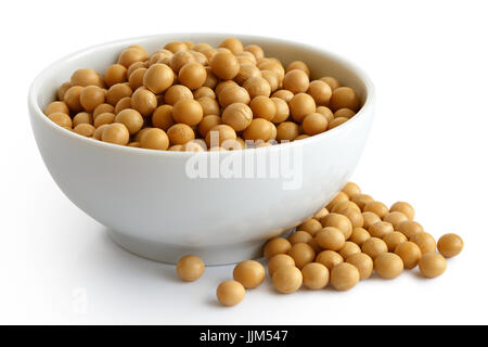 Dry soya beans  in white ceramic bowl isolated on white. Spilled beans Stock Photo