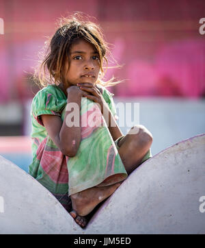 Poor girl sitting on a wall, portrait, Pushkar, Rajasthan, India Stock Photo