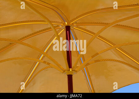 Golden metal parasol umbrella for ultraviolet light protection and sunshade on hot summer days Stock Photo
