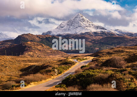 Road Leading towards Snow capped Ben Stack in the North of Scotland Stock Photo