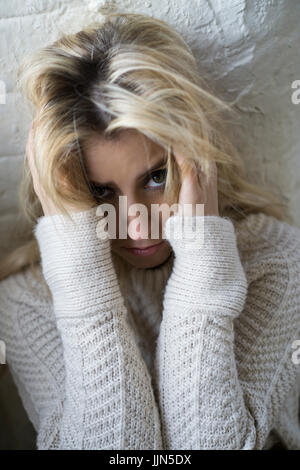 Sad young woman head in hands staring Stock Photo