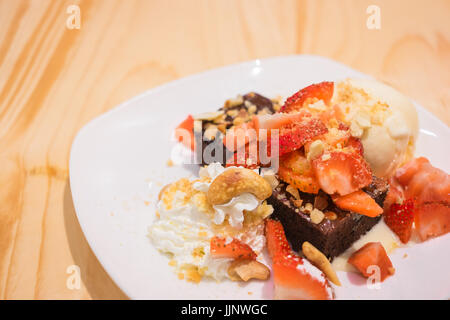 Chocolate Brownie and vanilla ice cream with whipping cream on dish Stock Photo