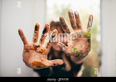 Close up of female artist showing her messy hands. Focus on hands of woman painter with color. Stock Photo