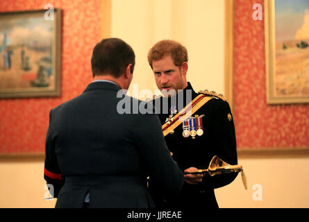Prince Harry presents the Firmin Sword of Peace to the Royal Air Force Police during an official visit to RAF Honington in Bury St Edmunds.