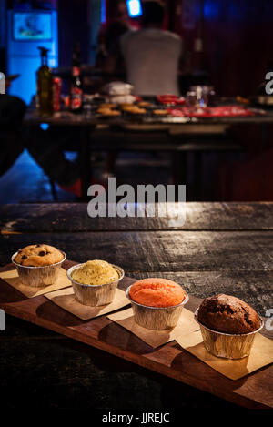 mixed freshly baked muffins on table in cozy coffeeshop interior Stock Photo