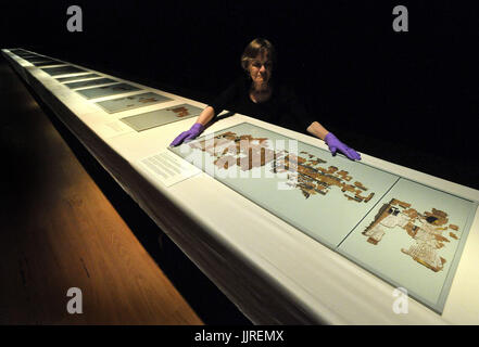 Head of conservation at the Fitzwilliam Museum in Cambridge, Julie Dawson, positions the final part of the Book of the Dead of Ramose, a 3,000-year-old Egyptian papyrus scroll, laid out in a 20 metre line by conservators at the museum, as an entire gallery has been set aside for its display, which is happening for one day only on Saturday 22 July. Stock Photo