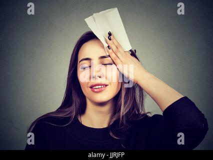 young woman wipes sweat from her forehead with a handkerchief Stock Photo