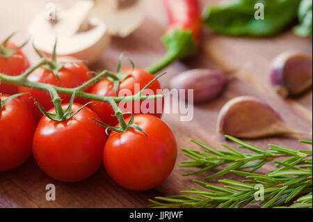 Closeup of cherry tomatoes on the vine And other vegetables Stock Photo