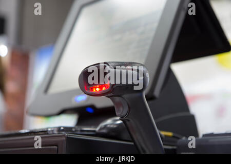 a hand held barcode scanner, scanning barcode ; shine red light;destop background Stock Photo