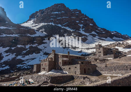 Toubkal national park in springtime with mount, cover by snow and ice, Refuge Toubkal, start point for hike to Jebel Toubkal, – highest peak of Atlas  Stock Photo