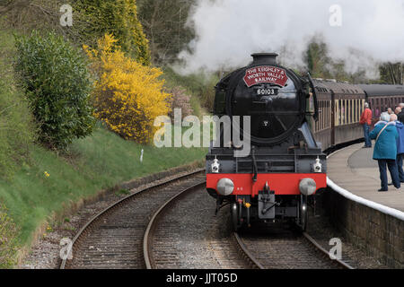 People on platform & iconic steam locomotive 60103 Flying Scotsman on tracks puffing smoke - Keighley and Worth Valley Railway station, England, UK. Stock Photo