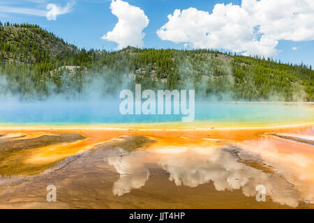 Clouds reflected in the the vivid rainbow colors of the Grand Prismatic Spring in Yellowstone National Park, Wyoming