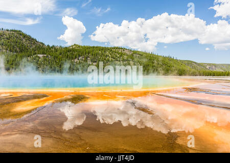 Clouds reflected in the the vivid rainbow colors of the Grand Prismatic Spring in Yellowstone National Park, Wyoming