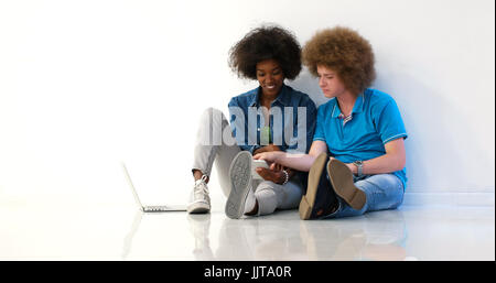 startup business and new mobile technology concept with young multiethnic couple in modern bright office interior working on laptop and tablet compute Stock Photo