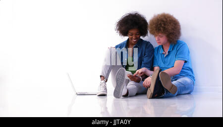 startup business and new mobile technology concept with young multiethnic couple in modern bright office interior working on laptop and tablet compute Stock Photo