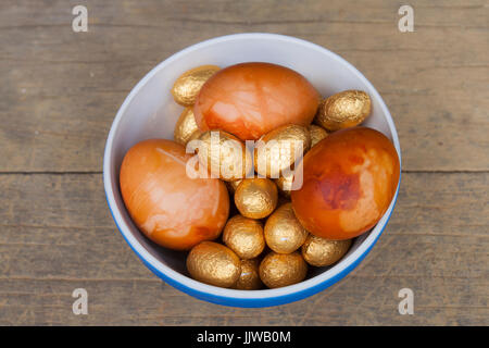 Golden Easter eggs in a bowl. Onions were used to give them an aesthetically pleasing golden look. Stock Photo