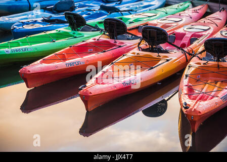 Colorful kayaks on a glassy lake at sunrise in the Blue Ridge Mountains of Northeast Georgia. (USA) Stock Photo