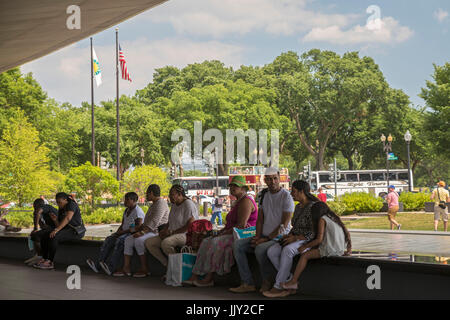 Washington, DC - Visitors to the National Museum of African American History and Culture sit by a pool outside the museum. Stock Photo