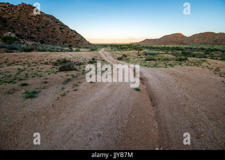 A dirt road leading through the Namib-Naukluft desert in Namibia, Africa. Stock Photo