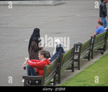 Asian refugee dressed Hijab scarf on George Square Glasgow street in the UK everyday scene Stock Photo