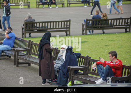 Asian refugee dressed Hijab scarf on George Square Glasgow street in the UK everyday scene Stock Photo