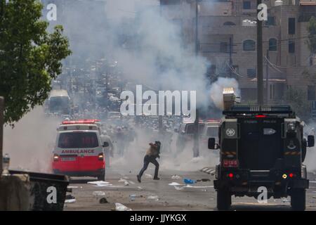 Bethlehem. 21st July, 2017. Palestinian protesters run to take cover from tear gas fired by Israeli soldiers during a protest at the main entrance of the West bank city of Bethlehem, on July 21, 2017. People protested against new Israeli security measures implemented at the entrance to the al-Aqsa mosque compound, which include metal detectors and cameras, following an attack that killed two Israeli policemen the previous week. Credit: Luay Sababa/Xinhua/Alamy Live News Stock Photo