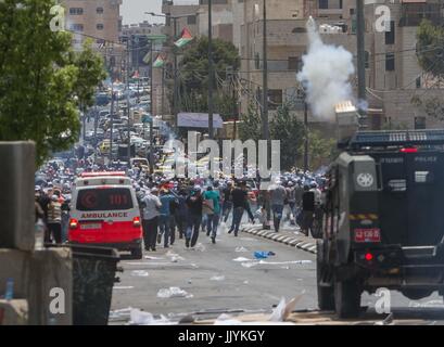 Bethlehem. 21st July, 2017. Palestinian protesters run to take cover from tear gas fired by Israeli soldiers during a protest at the main entrance of the West bank city of Bethlehem, on July 21, 2017. People protested against new Israeli security measures implemented at the entrance to the al-Aqsa mosque compound, which include metal detectors and cameras, following an attack that killed two Israeli policemen the previous week. Credit: Luay Sababa/Xinhua/Alamy Live News Stock Photo