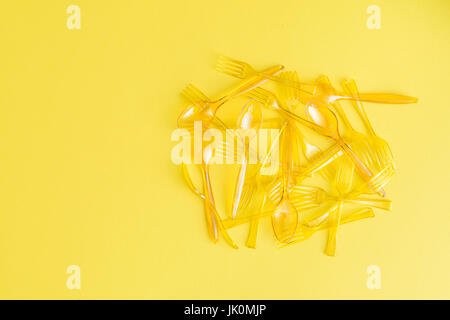 top view of pile of spoons and forks isolated on yellow Stock Photo