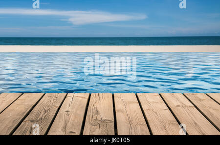 wooden floor with infinity pool on beach background Stock Photo