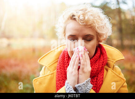 Unhealthy woman blowing her nose Stock Photo