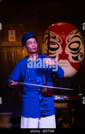Male musician playing traditional string instrument - Hoi An - 14 March 2017 Stock Photo