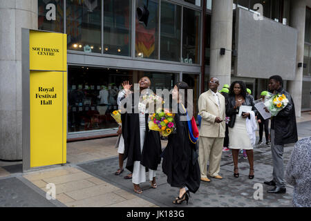 Lady graduates fling their rented mortarboard hats into the air after their graduation eremony, in celebration of their university academic achievement, outside the Festival Hall, on 20th July 2017, on the Southbank, London, England. Stock Photo