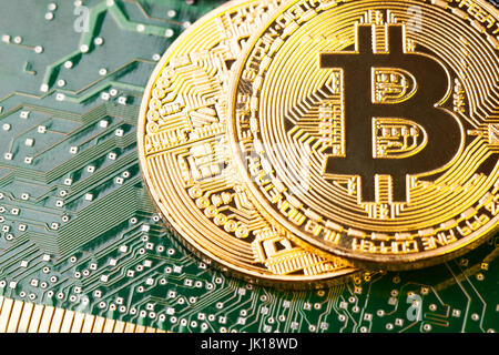 Golden Bitcoin Cryptocurrency on computer circuit board. Macro shot Stock Photo