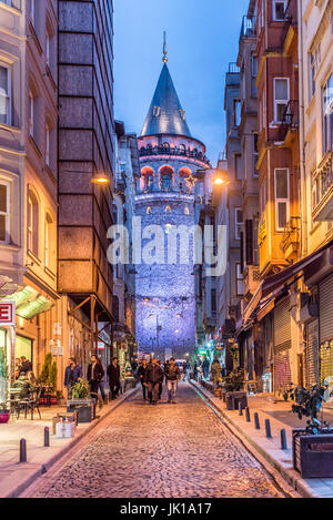 Night View of old narrow street with the Galata Tower(Turkish: Galata Kulesi)called Christ Tower by Genoese a famous medieval landmark in Istanbul. Stock Photo