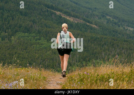 Fit and Active young girl hiking into nature looking at mountains, beautiful landscape, extreme lifestyle Stock Photo