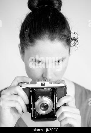 Woman uses vintage camera Stock Photo