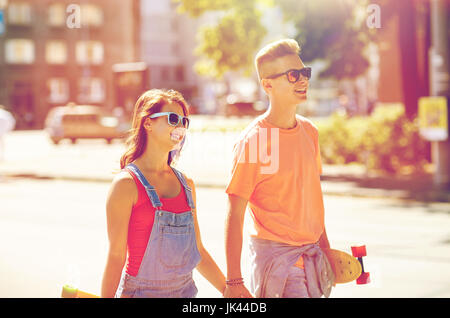 teenage couple with skateboards on city street Stock Photo