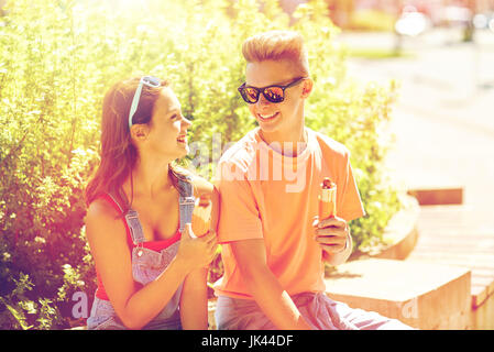 happy teenage couple eating hot dogs in city Stock Photo