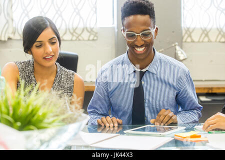 Smiling people using digital tablet in meeting Stock Photo