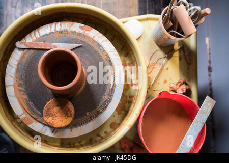 Cup and tools on pottery wheel Stock Photo